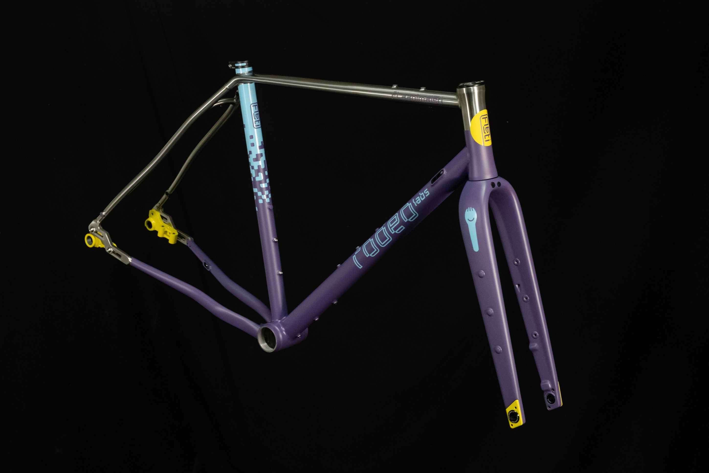 A stylish purple bicycle frame featuring a blue and yellow design, showcased against a black background.