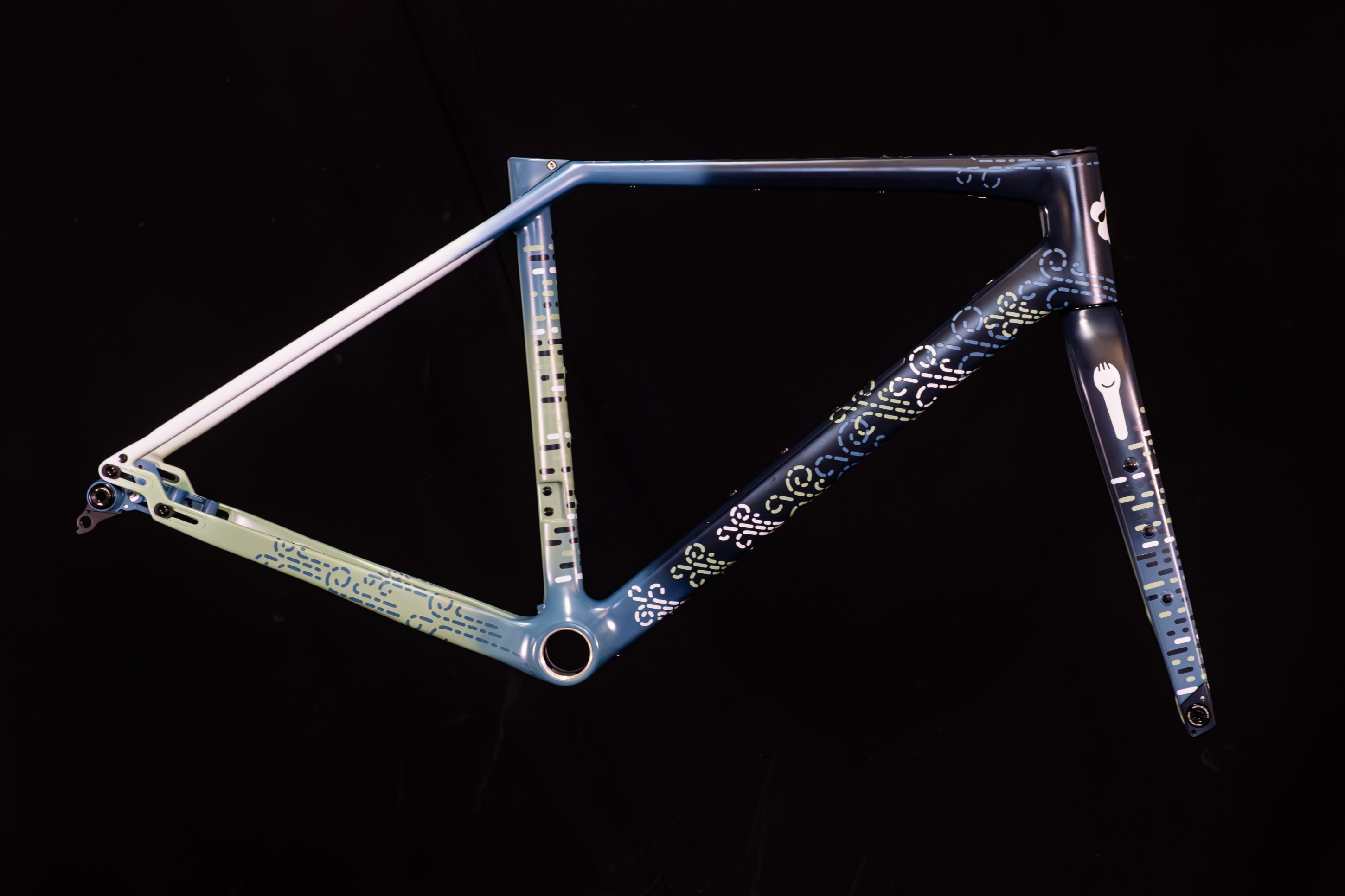 A modern bicycle frame featuring a gradient color scheme of blue and green with intricate patterns and designs.